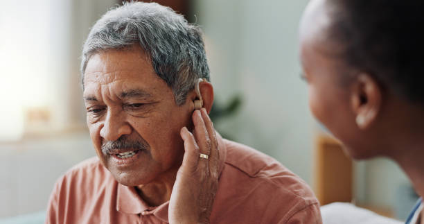 An adult with his hand on his ear